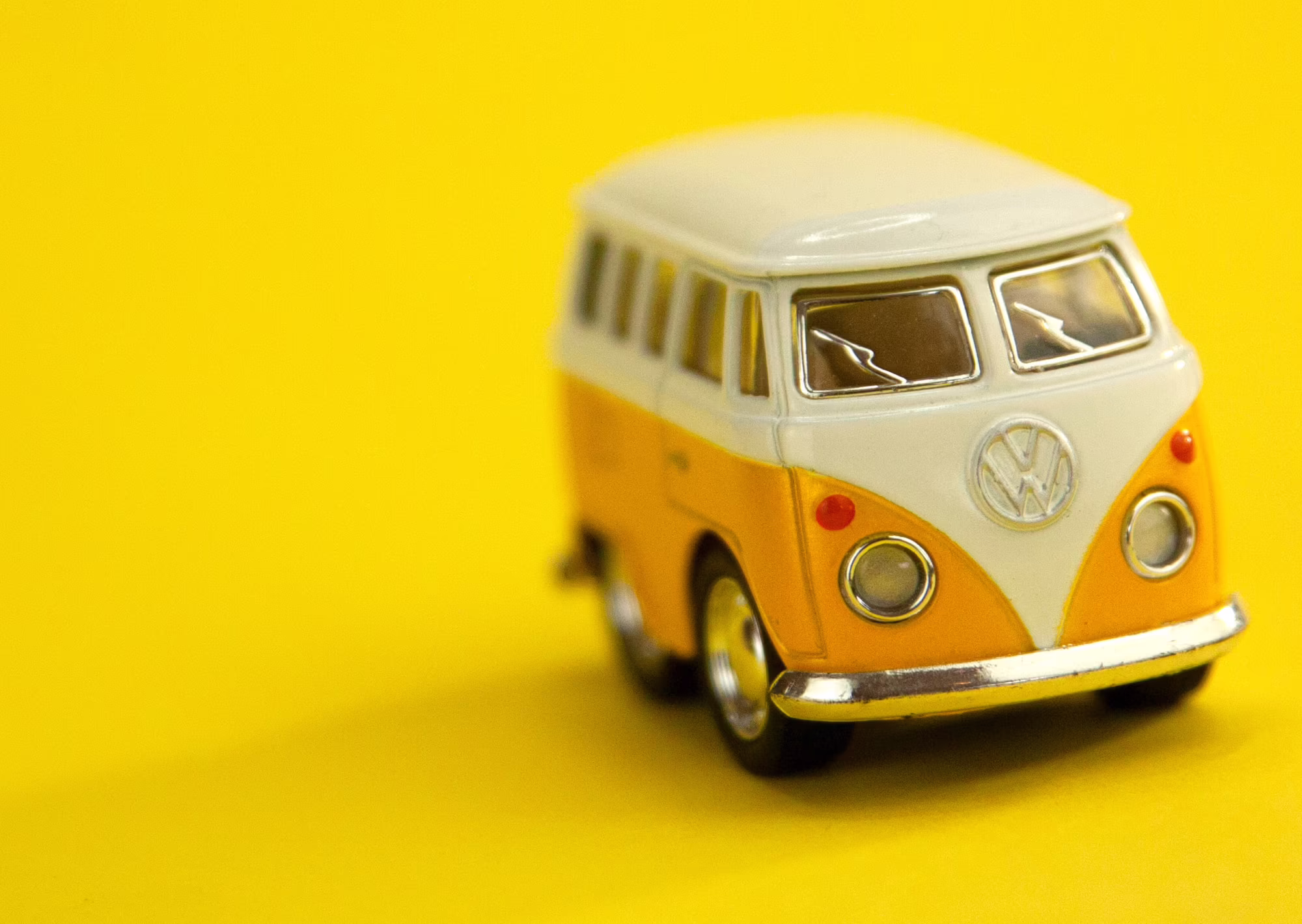 Gelb-weißer VW-Bus auf gelbem Hintergrund